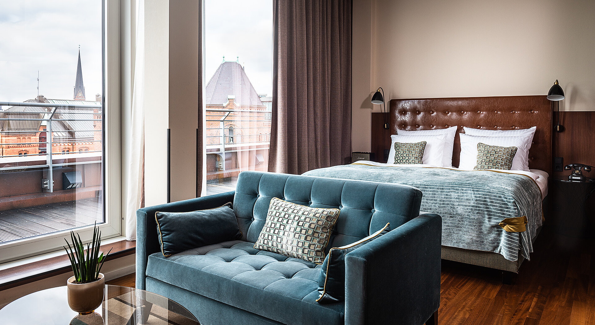 AMERON Hamburg Hotel Speicherstadt Juniorsuite Zimmer mit Bett und Couch 